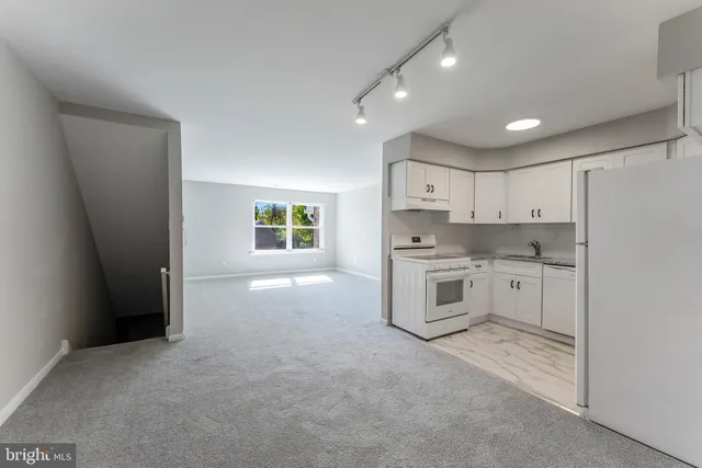 a kitchen with white cabinets and white appliances