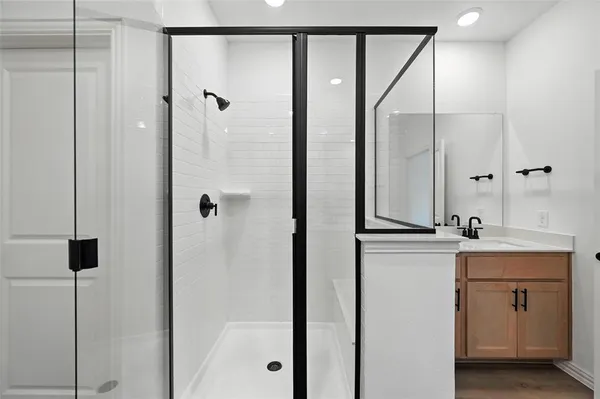 a bathroom with a shower sink and mirror