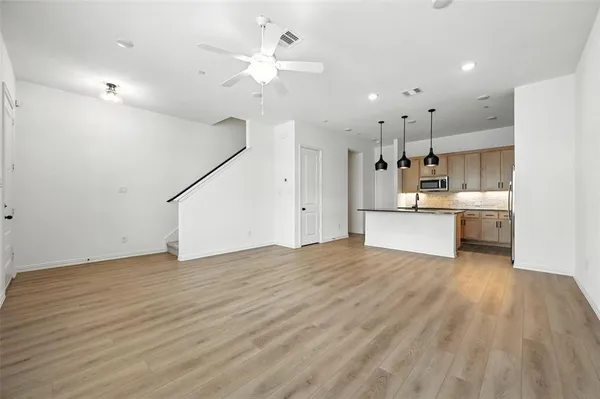 a view of a kitchen with a sink dishwasher a refrigerator and wooden floor
