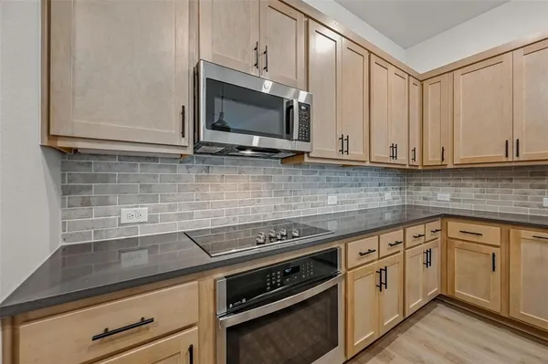 a kitchen with granite countertop white cabinets and stainless steel appliances