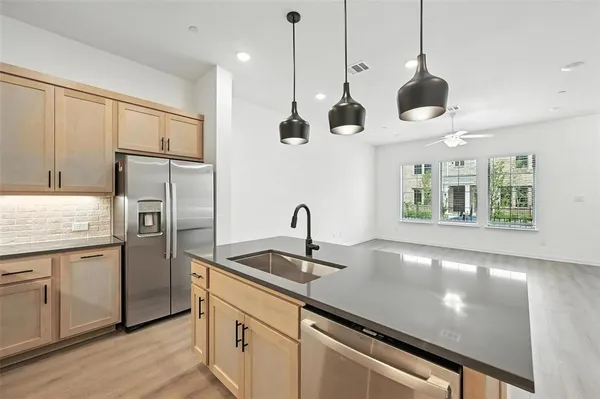 a kitchen with stainless steel appliances granite countertop a sink a refrigerator and a granite counter tops