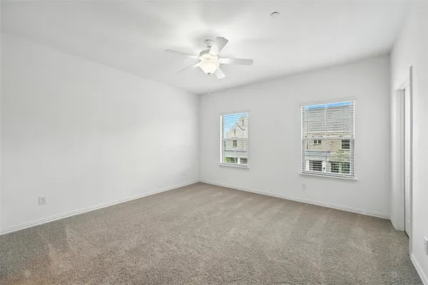 a view of a big room with windows and chandelier fan