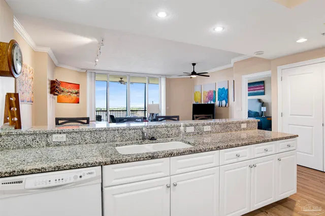 a kitchen with granite countertop a sink and white cabinets