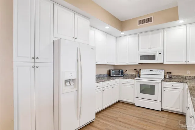 a kitchen with stainless steel appliances white cabinets and a sink