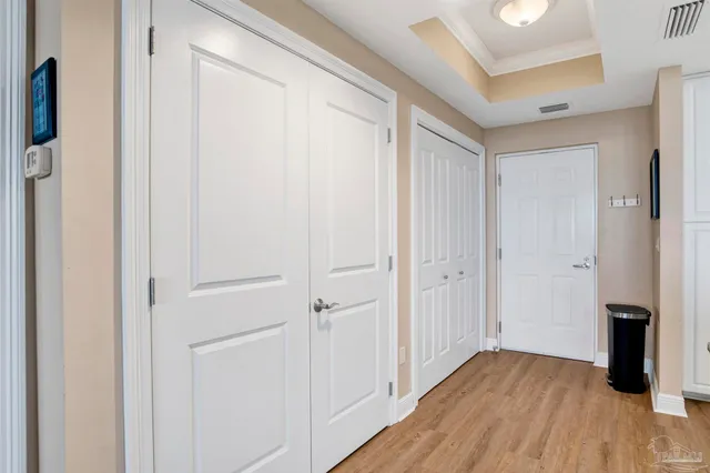 a view of a hallway with wooden floor and staircase
