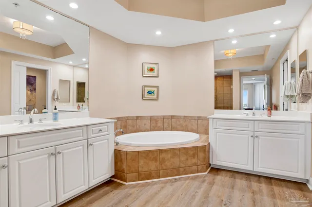 a bathroom with a tub a sink and mirror