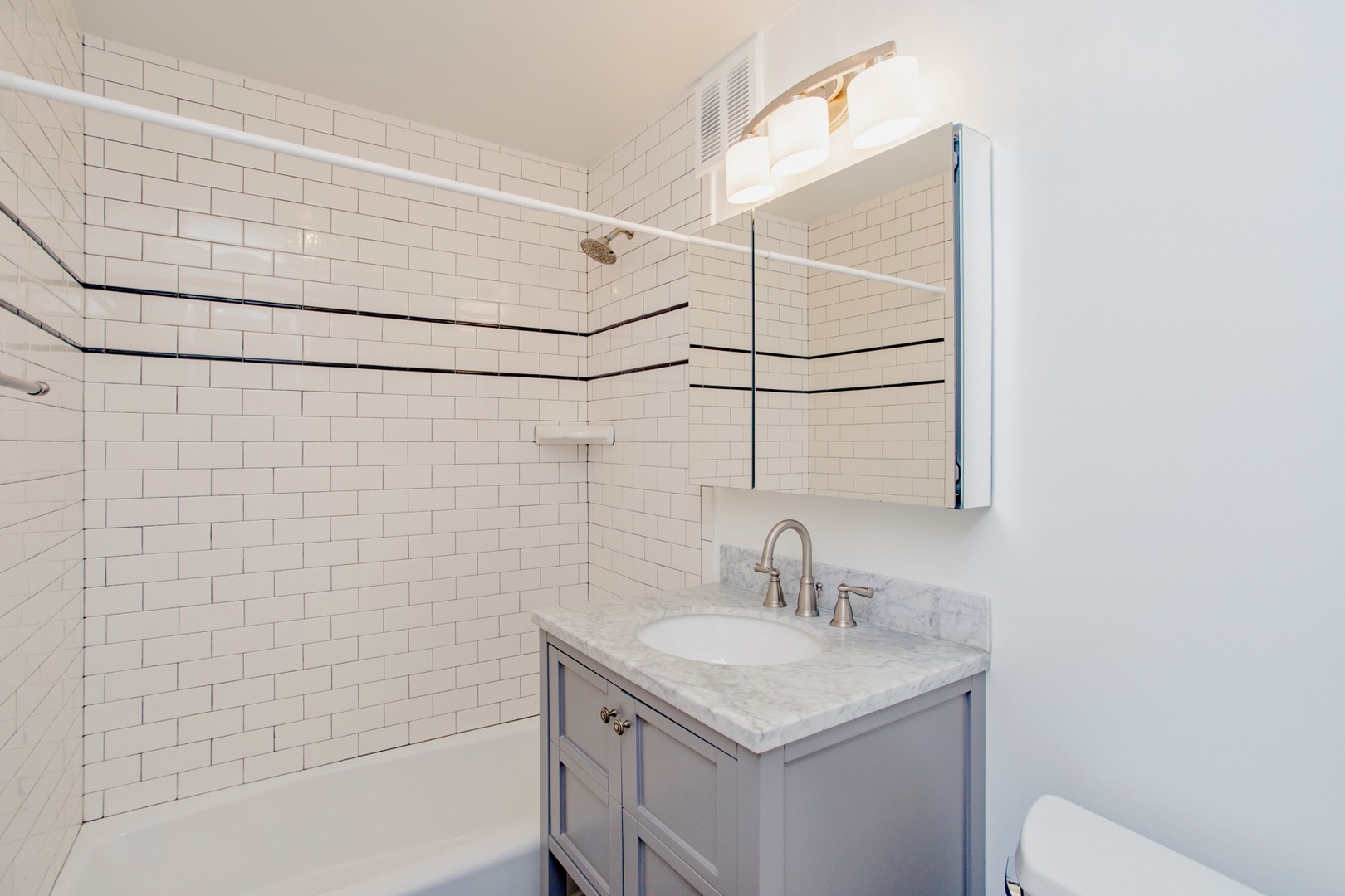 655 West Irving Park Road, Unit 4407 Chicago, IL 60613 - Photo 11 of 19 a bathroom with a sink vanity and a shower