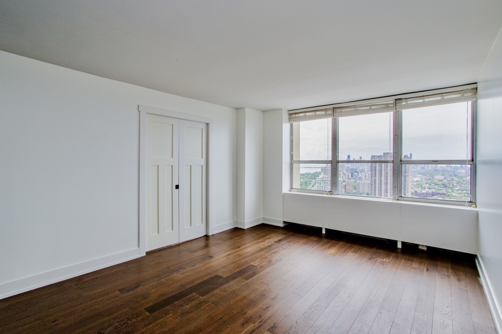 655 West Irving Park Road, Unit 4407 Chicago, IL 60613 - Photo 4 of 19 an empty room with wooden floor and windows