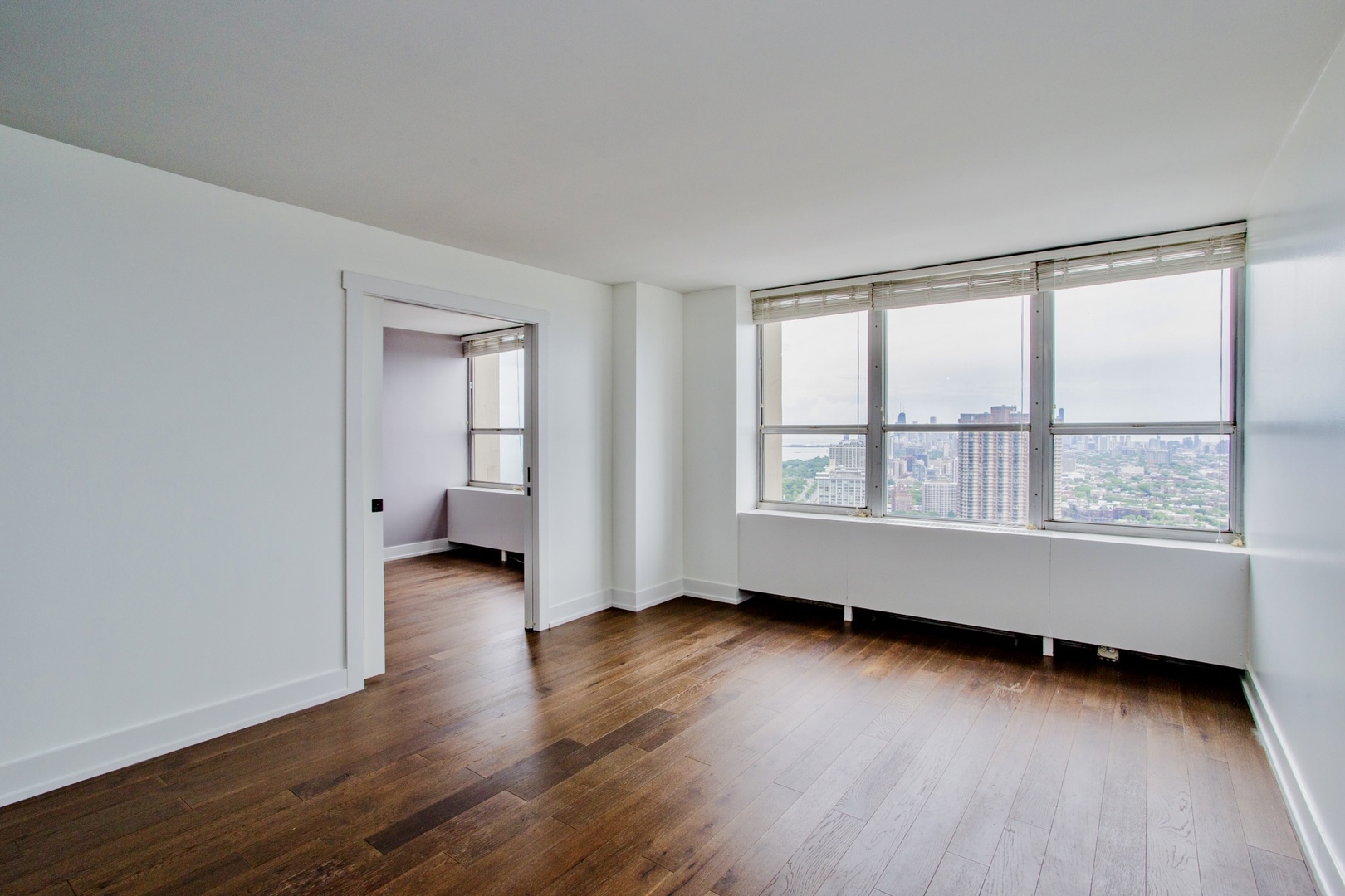 655 West Irving Park Road, Unit 4407 Chicago, IL 60613 - Photo 5 of 19 an empty room with wooden floor and windows