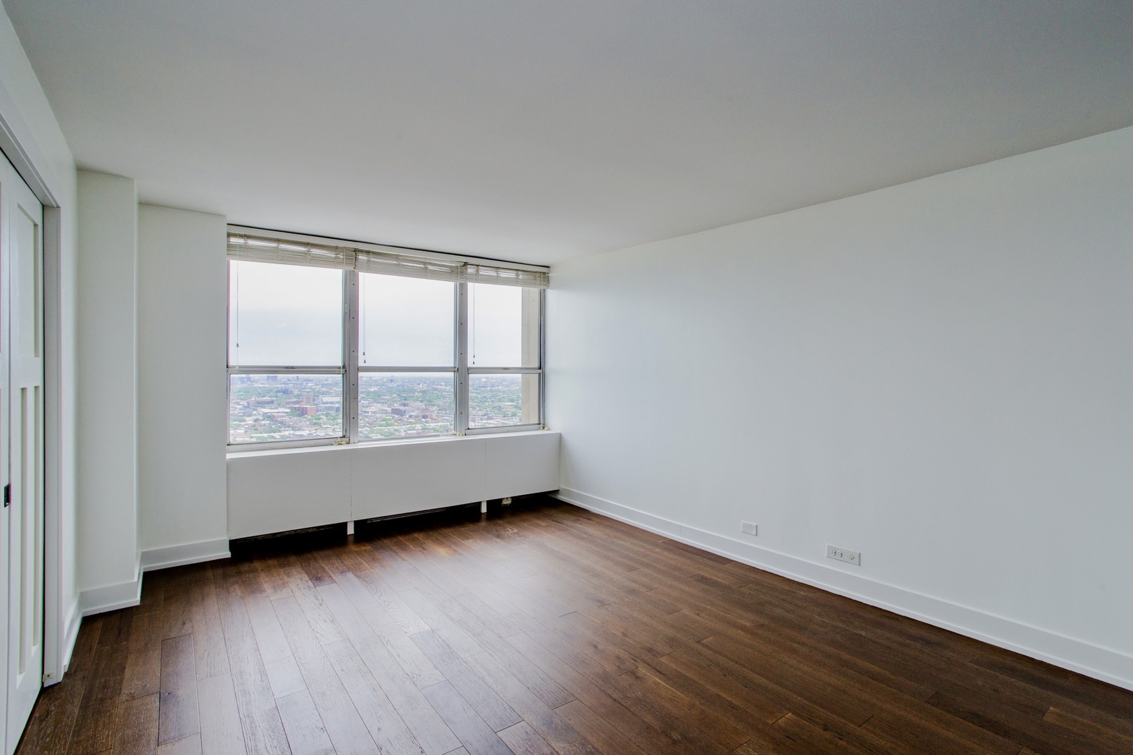 655 West Irving Park Road, Unit 4407 Chicago, IL 60613 - Photo 6 of 19 an empty room with wooden floor and windows