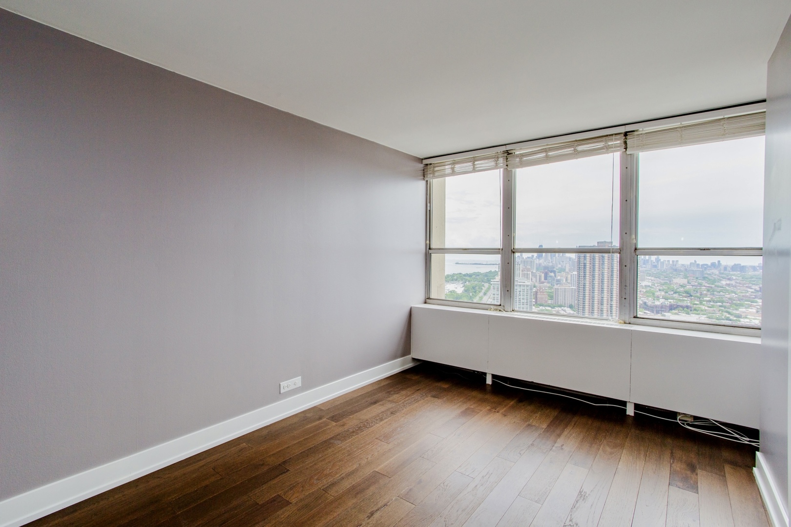 655 West Irving Park Road, Unit 4407 Chicago, IL 60613 - Photo 9 of 19 an empty room with wooden floor and windows