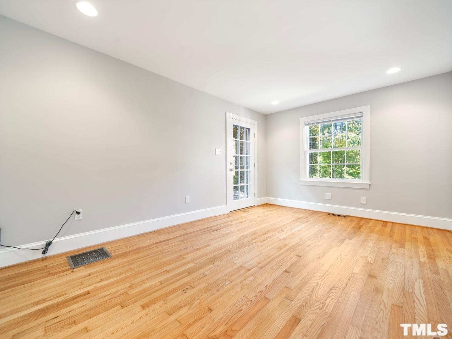 214 Faircloth Street Raleigh, NC 27607 - Photo 12 of 21 an empty room with wooden floor and windows