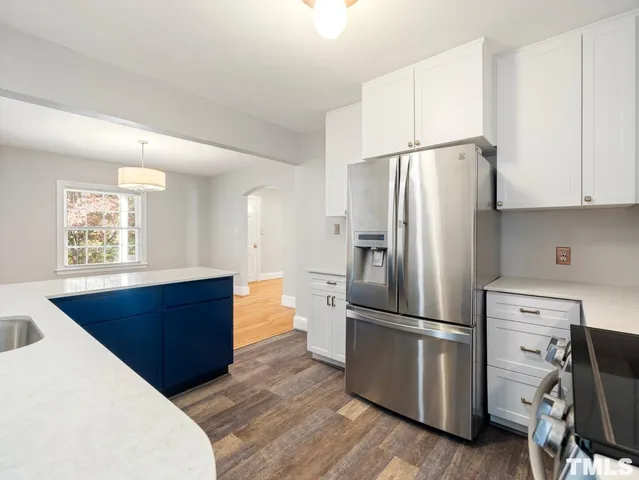 a kitchen with stainless steel appliances a refrigerator and wooden cabinets