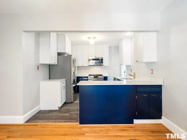 a kitchen with a sink cabinets and wooden floor