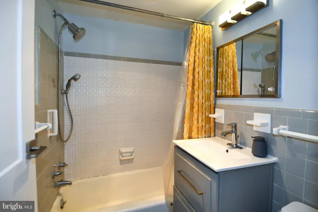 a bathroom with a sink vanity mirror and a bathtub