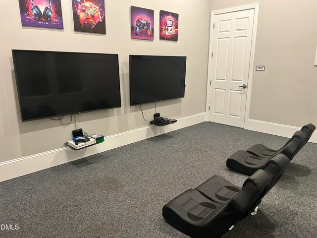 a room with a table chairs and a flat screen tv