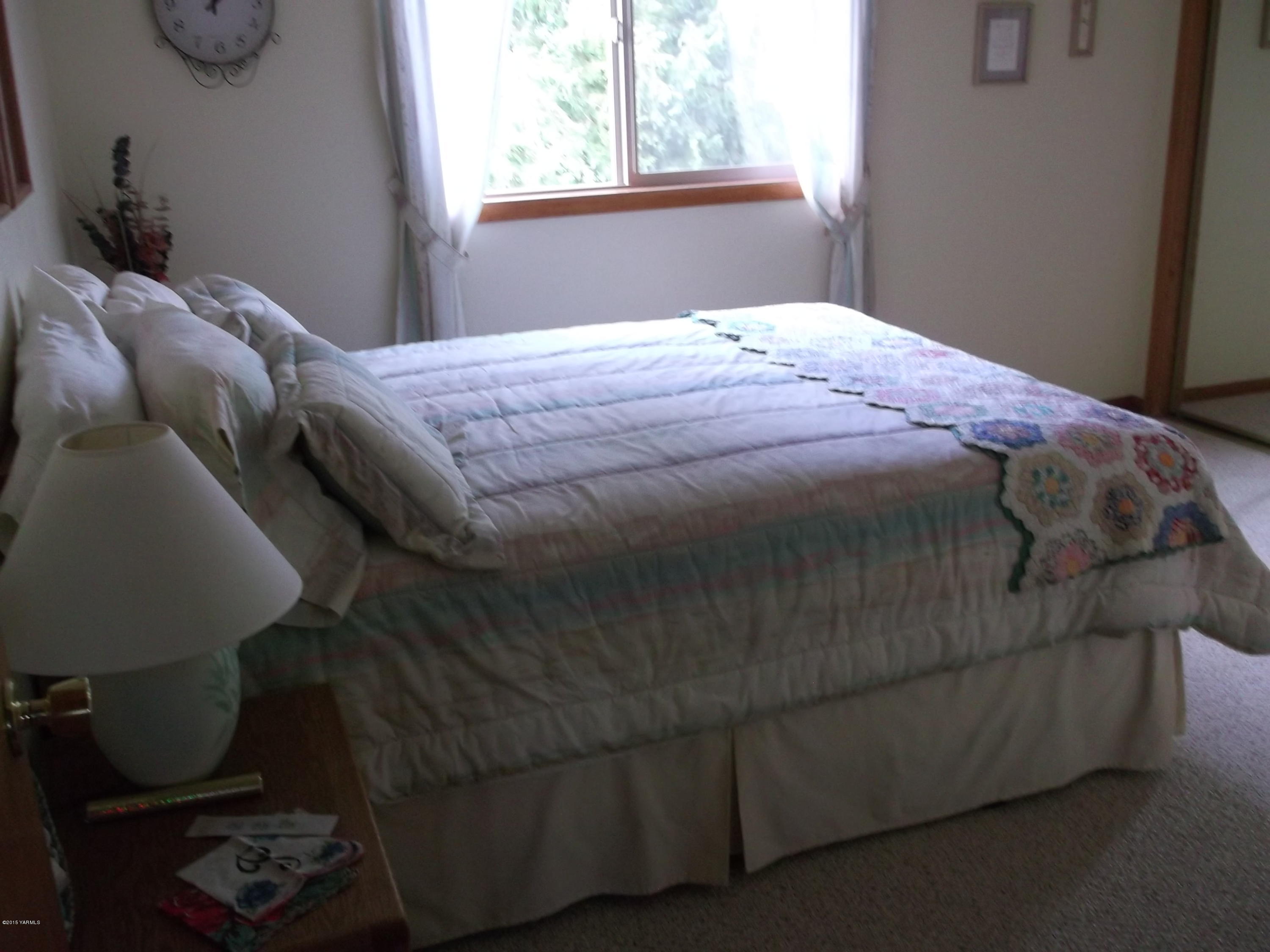 3161 Scoon Road Sunnyside, WA 98944 - Photo 7 of 25 a bed sitting in a bedroom next to a window
