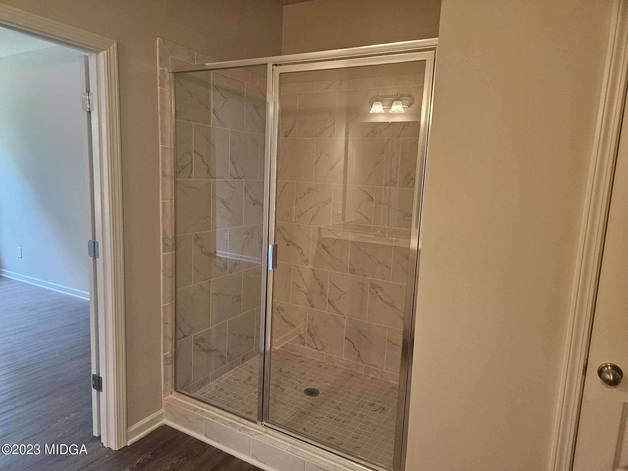 231 Presidents Way Forsyth, GA 31029 - Photo 15 of 32 a bathroom with a glass shower door