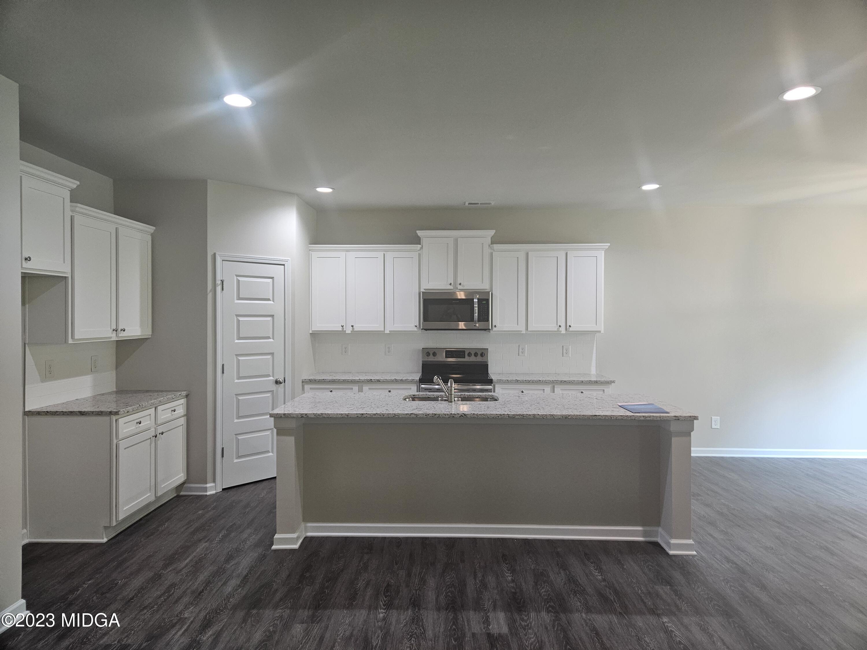 231 Presidents Way Forsyth, GA 31029 - Photo 4 of 32 a kitchen with stainless steel appliances granite countertop a refrigerator sink and white cabinets