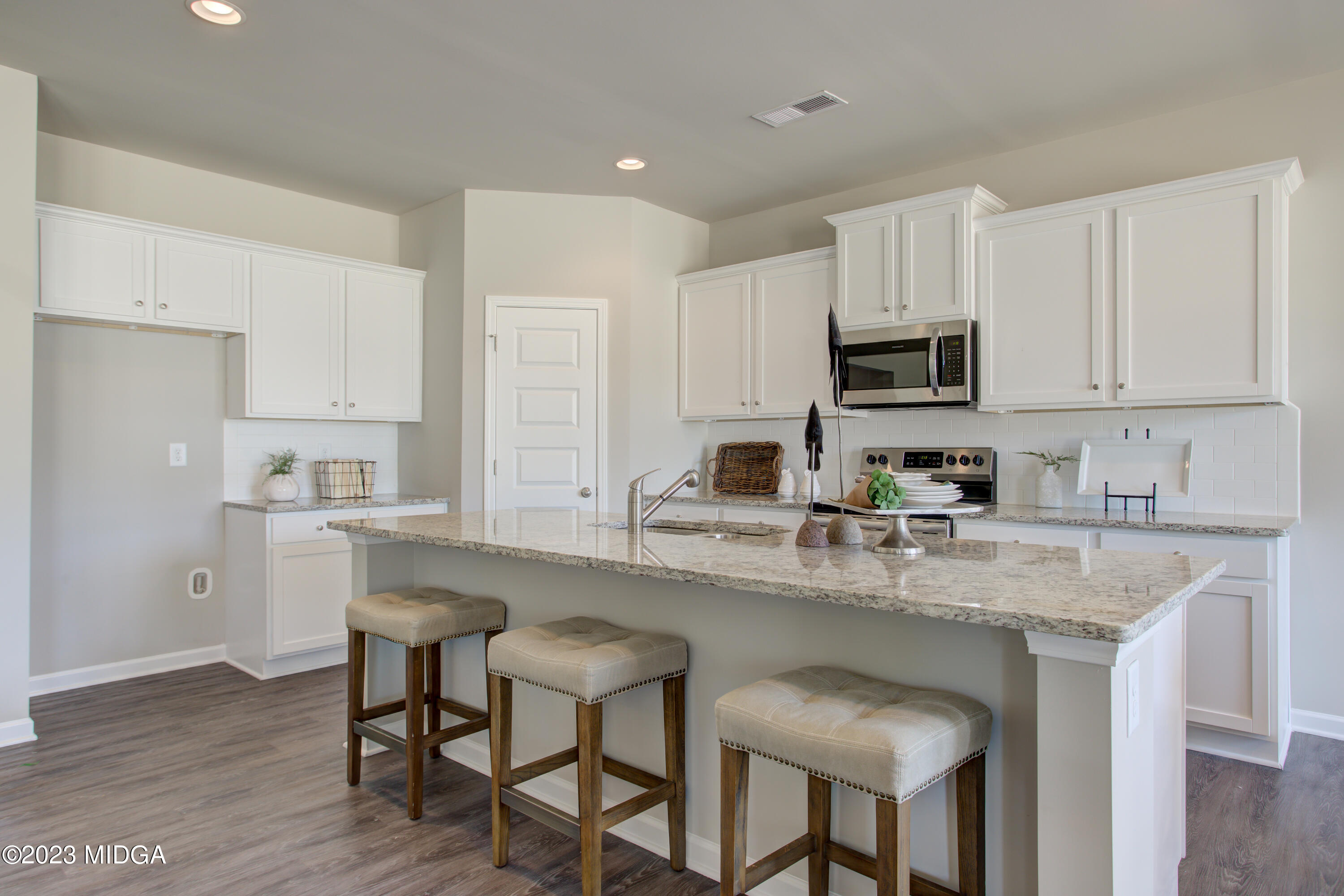 231 Presidents Way Forsyth, GA 31029 - Photo 5 of 32 a kitchen with stainless steel appliances granite countertop a table chairs sink refrigerator and cabinets