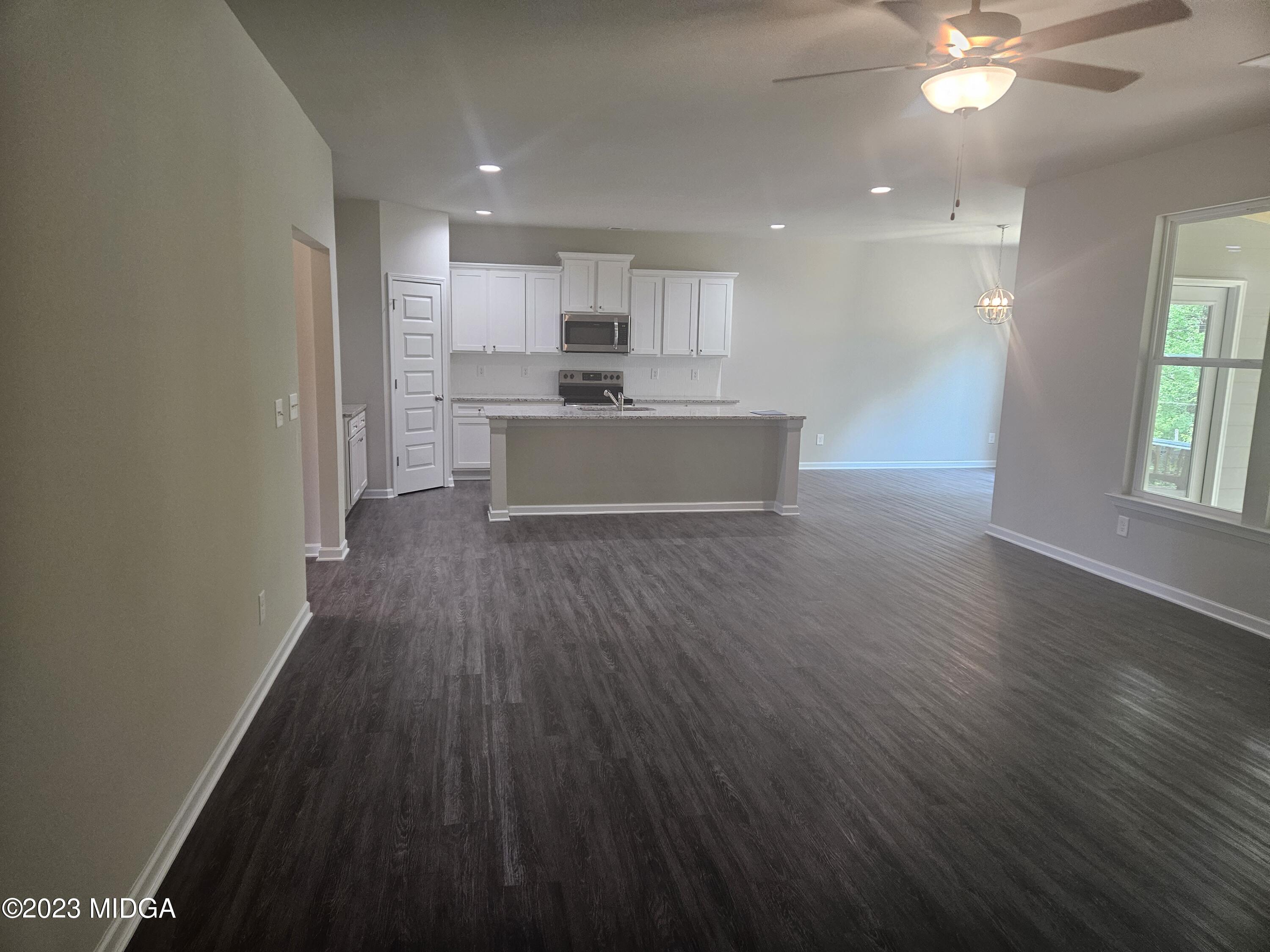 231 Presidents Way Forsyth, GA 31029 - Photo 6 of 32 a large kitchen with kitchen island a sink dishwasher a stove and a refrigerator with wooden floor