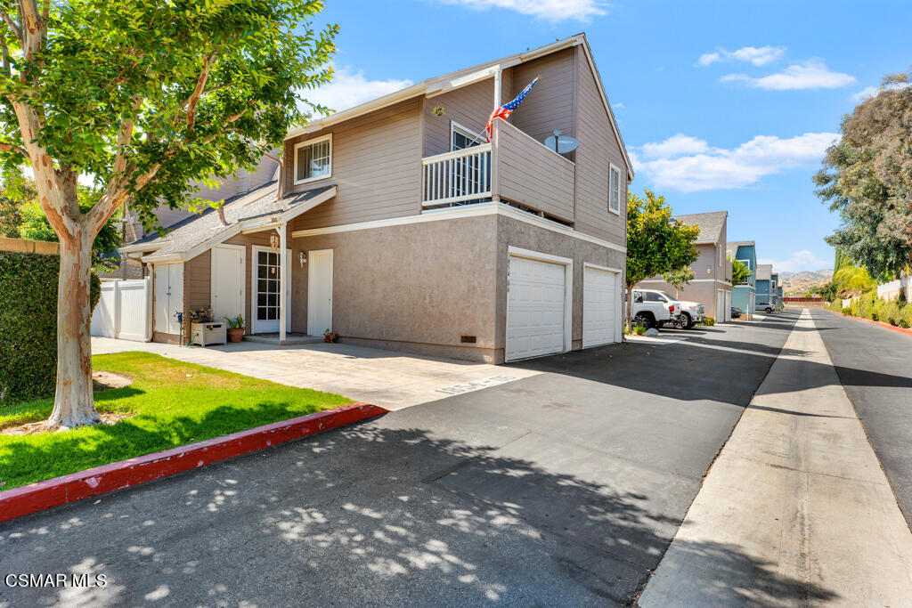 1854 Rory Lane, Unit 6 Simi Valley, CA 93063 - Photo 2 of 26 a front view of a house with a yard and garage