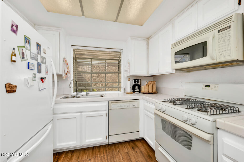 1854 Rory Lane, Unit 6 Simi Valley, CA 93063 - Photo 9 of 26 a kitchen with white cabinets and white appliances