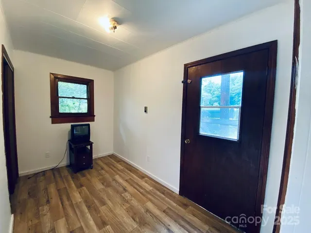 a view of a hallway with wooden floor and a cabinet