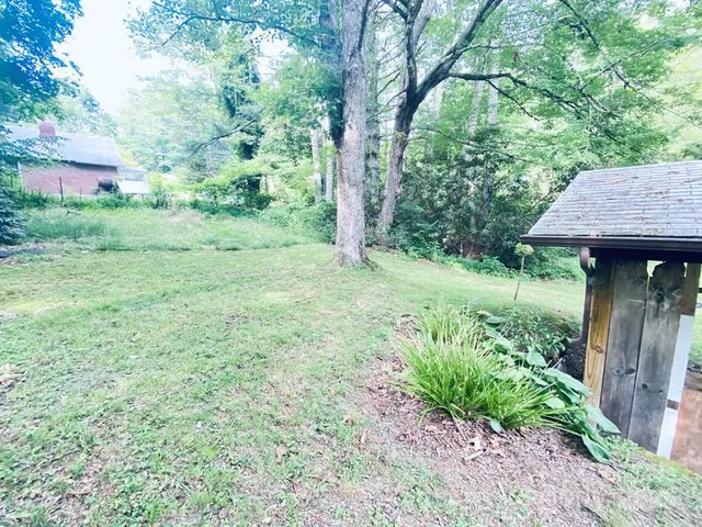 a backyard of a house with a yard and outdoor seating