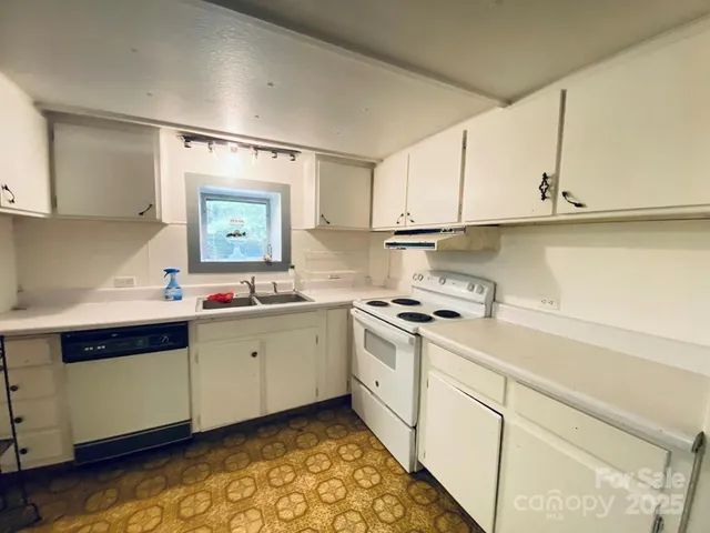 a kitchen with granite countertop a sink stainless steel appliances and cabinets