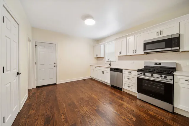 a kitchen with stainless steel appliances white cabinets and a stove top oven