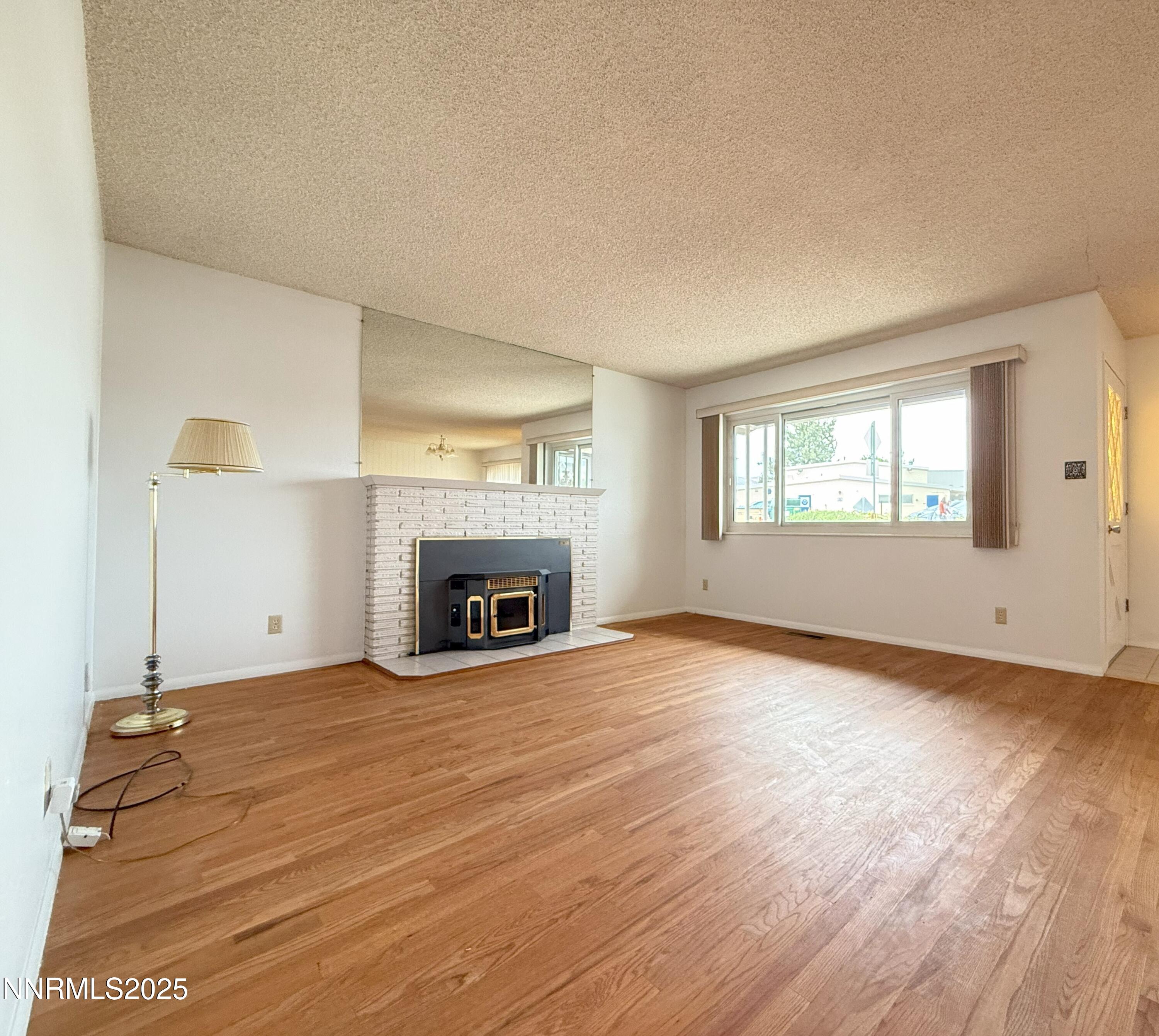 1480 Grandview Avenue Reno, NV 89503 - Photo 5 of 42 an empty room with windows fireplace and wooden floor