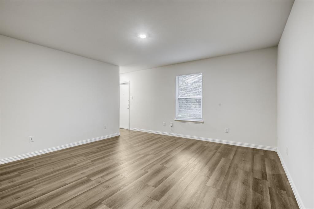 4229 Spring Avenue Dallas, TX 75210 - Photo 15 of 22 an empty room with wooden floor and windows