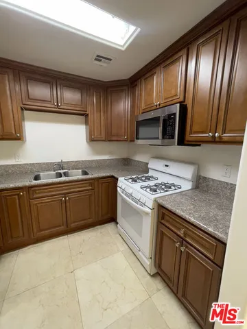 a kitchen with granite countertop stainless steel appliances and stove top oven