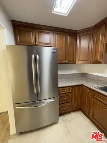 a metallic refrigerator freezer sitting in a kitchen