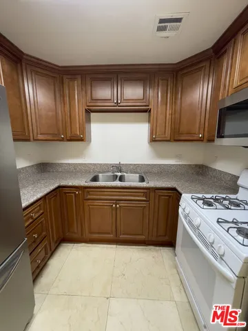 a kitchen with granite countertop stainless steel appliances and cabinets