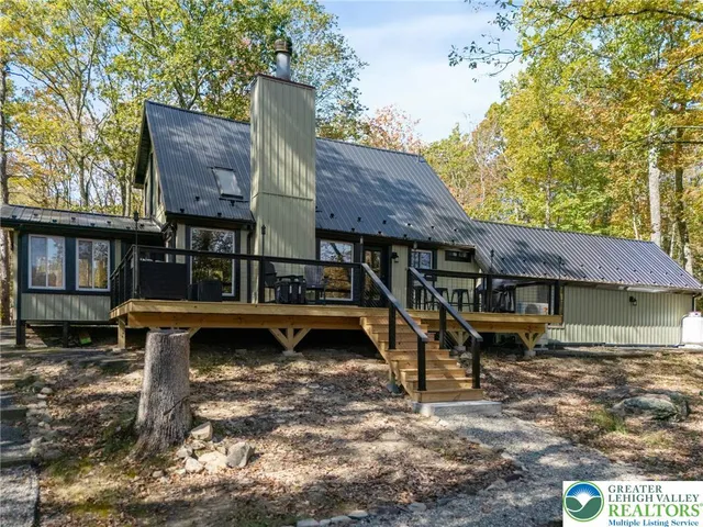 a view of a house with wooden deck front of house