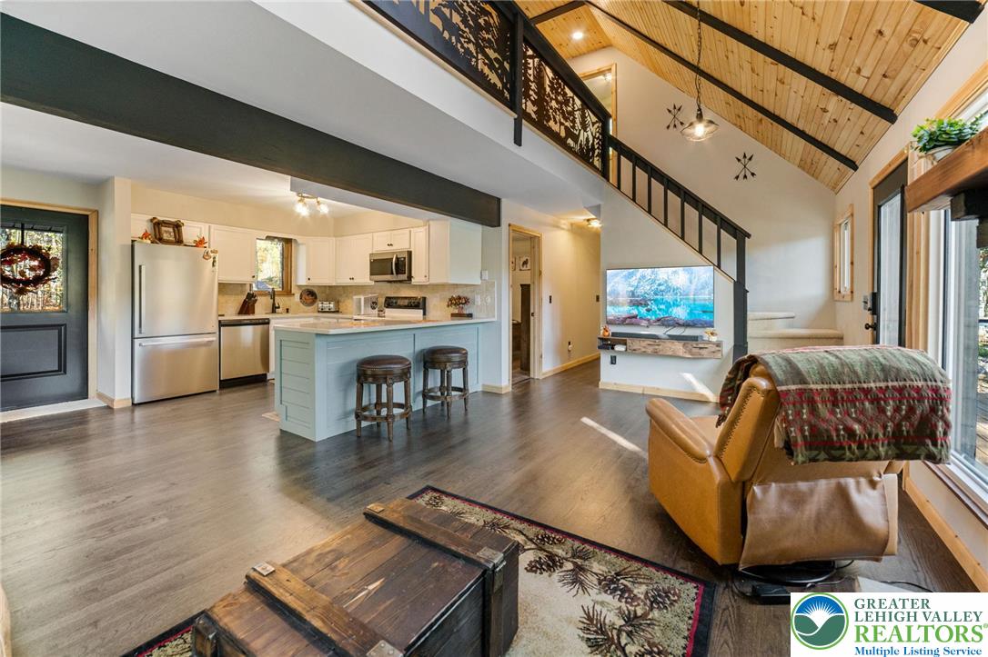 809 Boulder Court North Hawley, PA 18428 - Photo 18 of 43 a living room with stainless steel appliances furniture a rug and a kitchen view