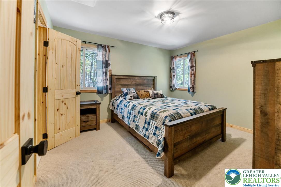 809 Boulder Court North Hawley, PA 18428 - Photo 30 of 43 a bedroom with a bed and a chandelier