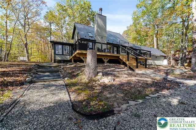 a large living room with stainless steel appliances furniture a fireplace and a open kitchen view