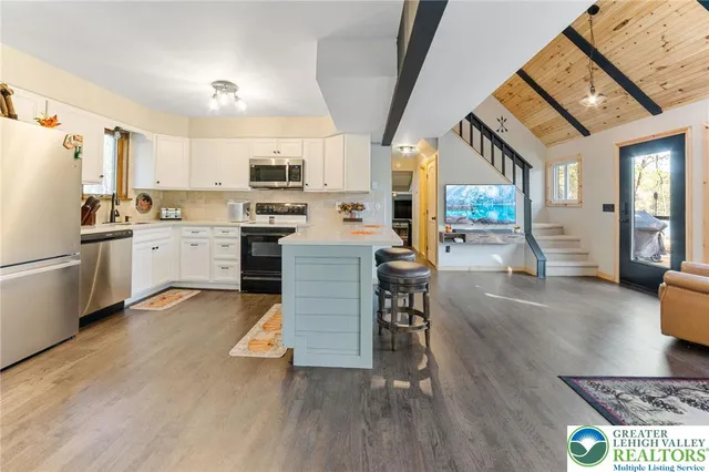 a kitchen with stainless steel appliances a sink cabinets and wooden floor