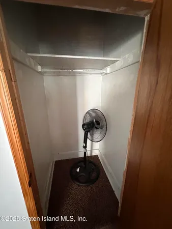 a walk in closet with wooden floor