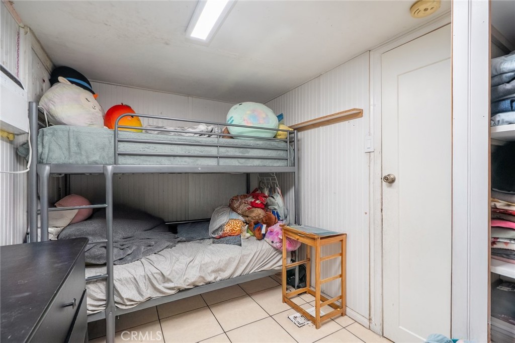 16002 Atlantic Avenue, Unit C11 Compton, CA 90221 - Photo 11 of 19 a bedroom with a bed and a chandelier