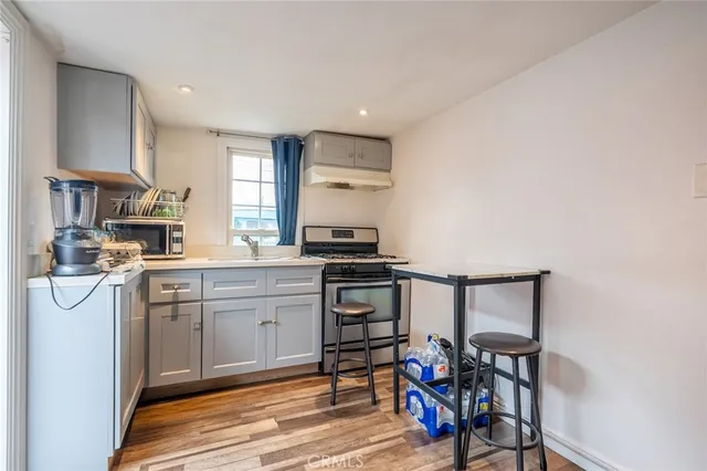 a kitchen with stainless steel appliances a stove a sink and white cabinets