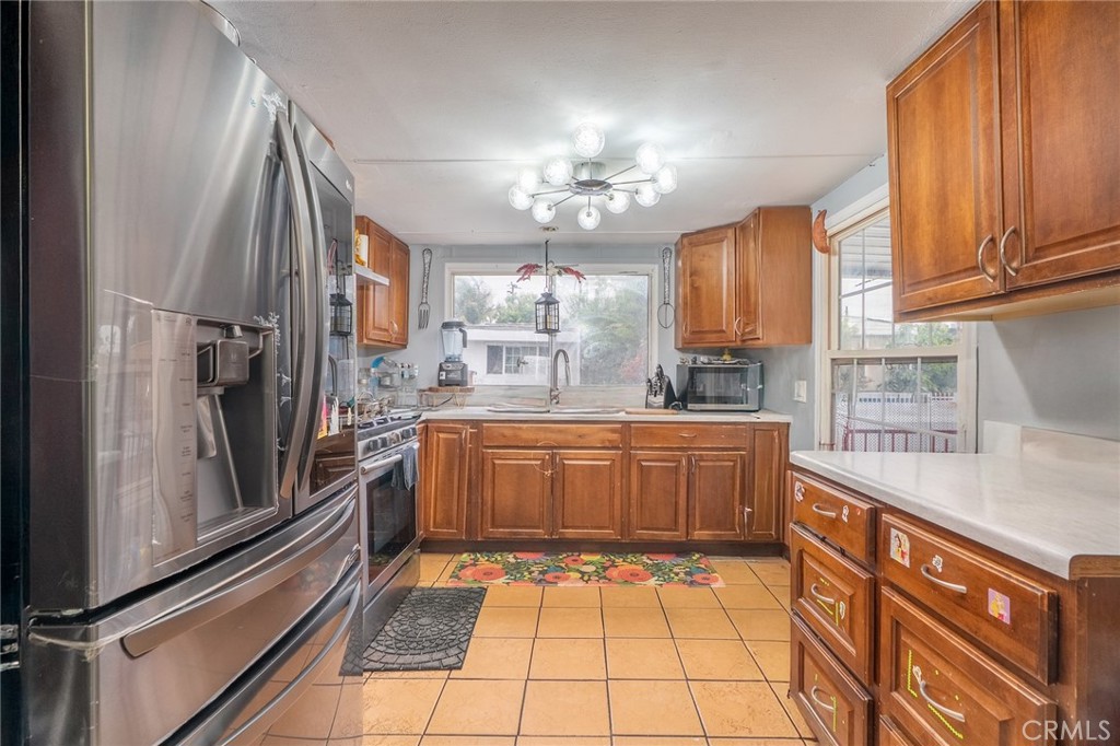 16002 Atlantic Avenue, Unit C11 Compton, CA 90221 - Photo 7 of 19 a kitchen with stainless steel appliances granite countertop a refrigerator and a stove top oven