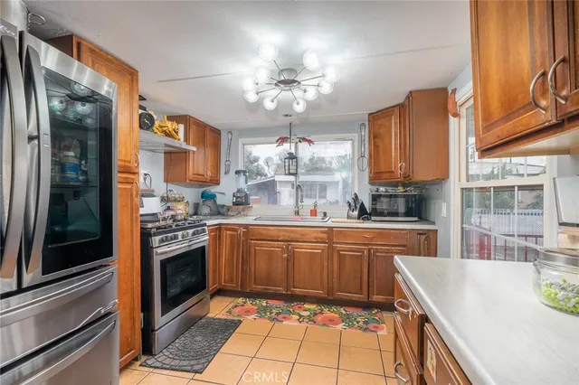 a kitchen with stainless steel appliances granite countertop a sink a stove and a refrigerator