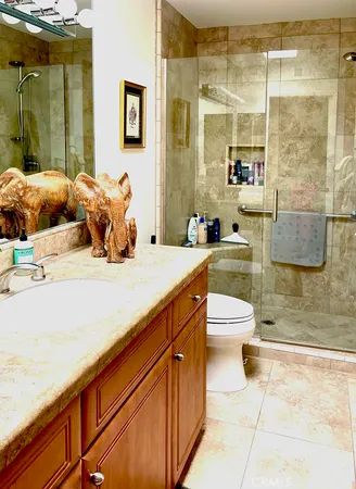 a bathroom with a granite countertop sink a toilet and shower