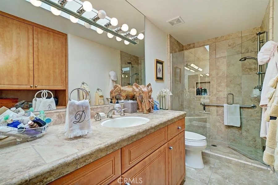 8 Cadiz Drive Rancho Mirage, CA 92270 - Photo 14 of 26 a bathroom with a granite countertop sink a toilet and a shower