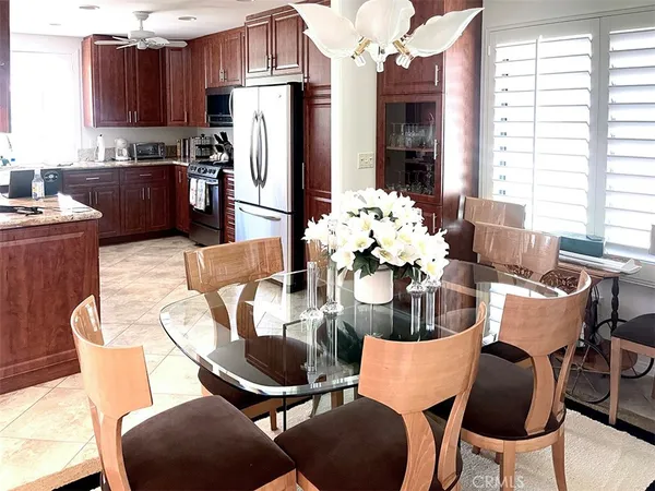 a dining room filled chandelier and kitchen view