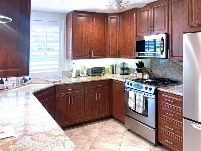 a kitchen with stainless steel appliances granite countertop a sink stove and cabinets